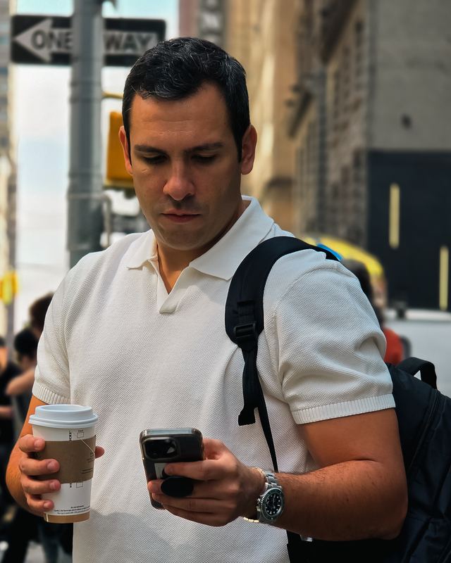 Borja Iglesias en la calle, con un café y el móvil